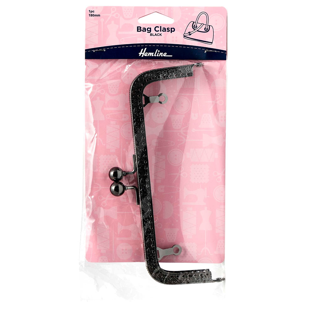 A Hemline brand black glittery bag clasp tool with silver metal tips, packaged in a clear plastic sleeve on a pink cardboard backing.