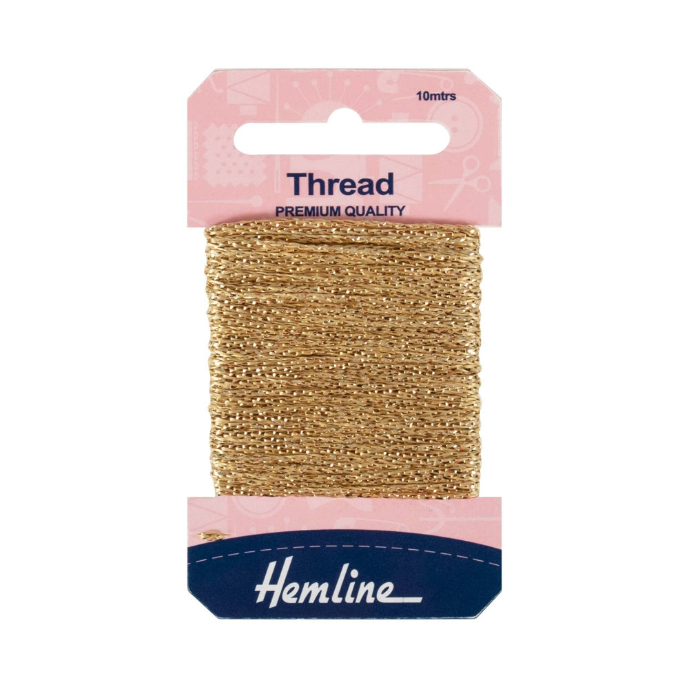 A 10-meter spool of Hemline light gold embroidery thread in its original pink and navy blue retail packaging, shown against a plain white background.