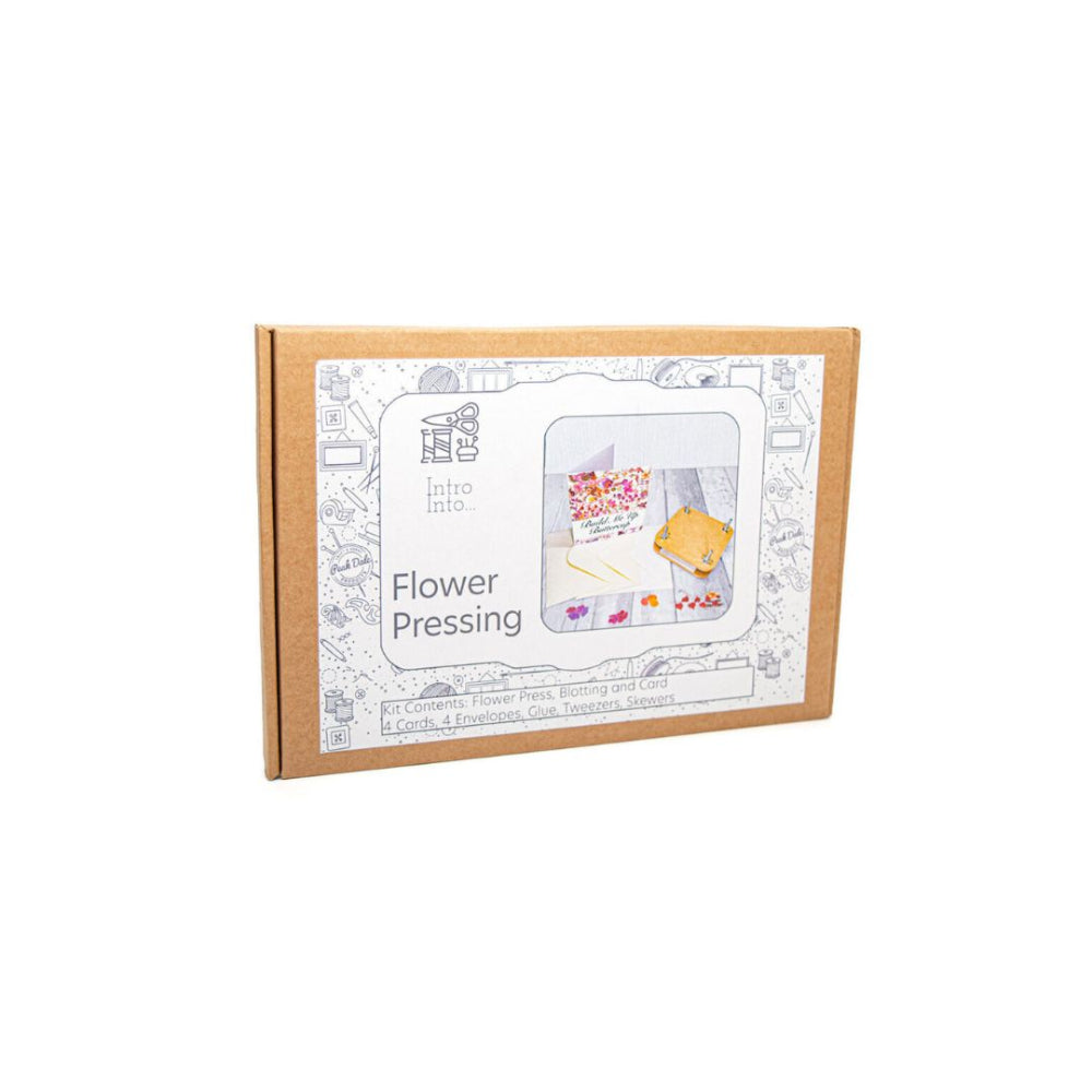 A cardboard box for an 'Intro to Flower Pressing' kit, featuring a white label with black line drawings and text, set against a plain white background.