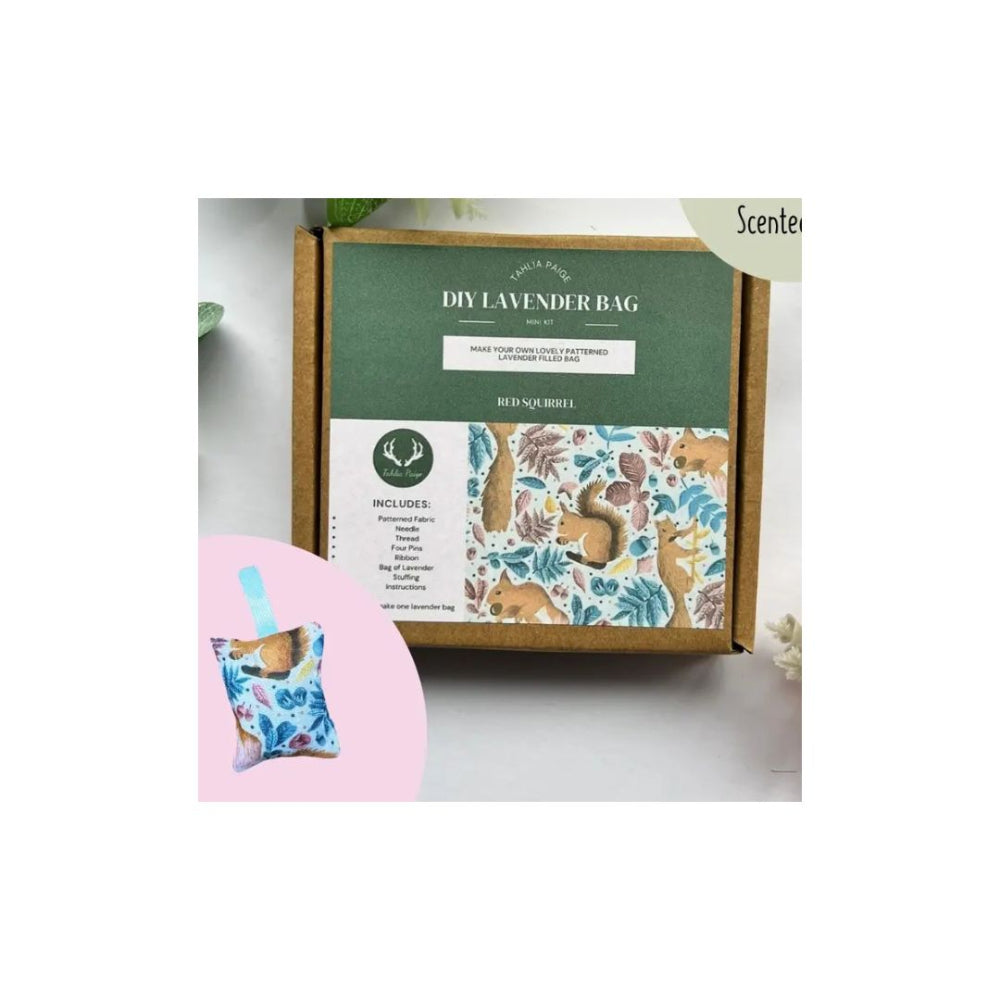 A DIY lavender bag kit in a brown cardboard box with a green and white label, shown on a light grey background with decorative leaves and a pink circle containing a small finished lavender bag.