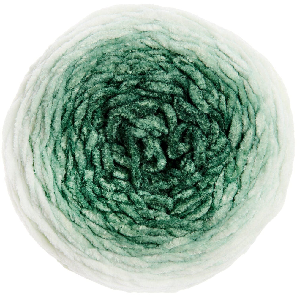 A single round skein of variegated yarn photographed from above on a plain white background. The yarn has an ombre color treatment transitioning from off-white at the outer edges to medium and deep green toward the center.