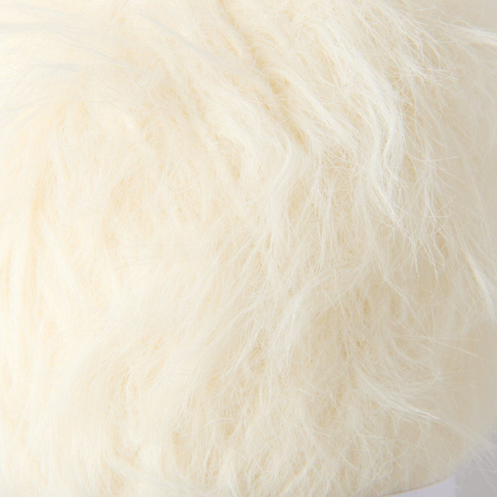 A close-up of fluffy faux fur fabric in a warm off-white or cream color.