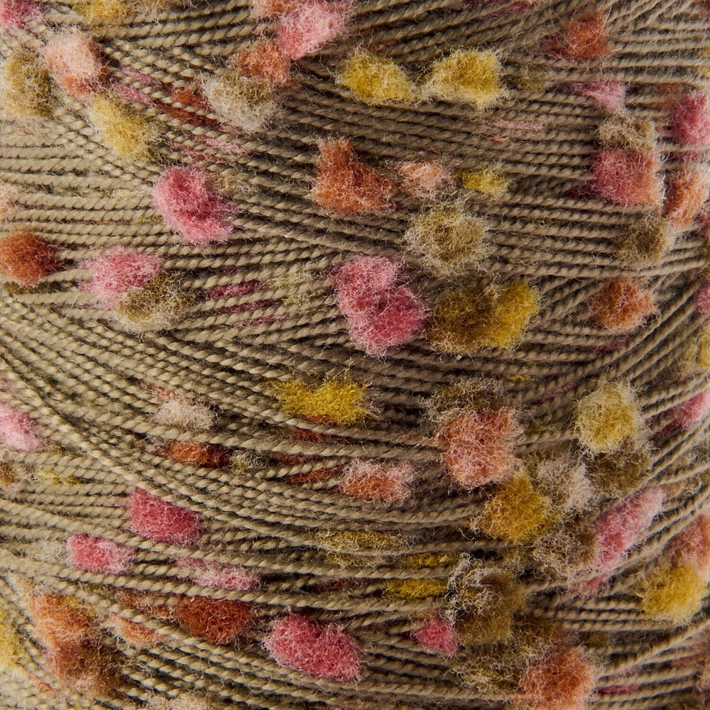 Close-up of a textured yarn ball with a chunky, fuzzy pom-pom effect in a warm taupe-brown base with scattered pink, mustard yellow, and rust-orange flecks.