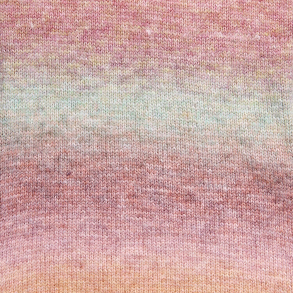 A close-up of a knitted fabric with a soft gradient pattern blending dusty pink, muted sage green, and light peach tones.