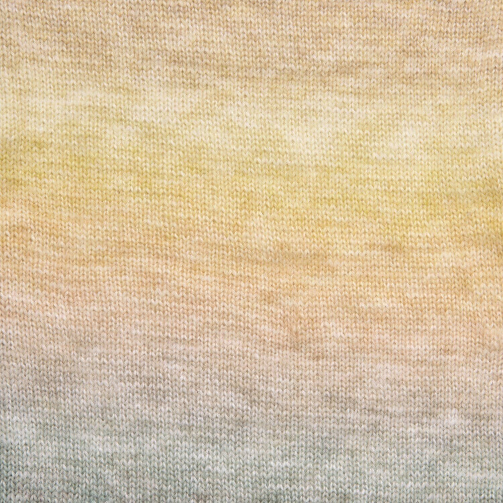A close-up of a knitted fabric with a soft ombre gradient transitioning from pale yellow at the top through warm beige to light gray at the bottom.