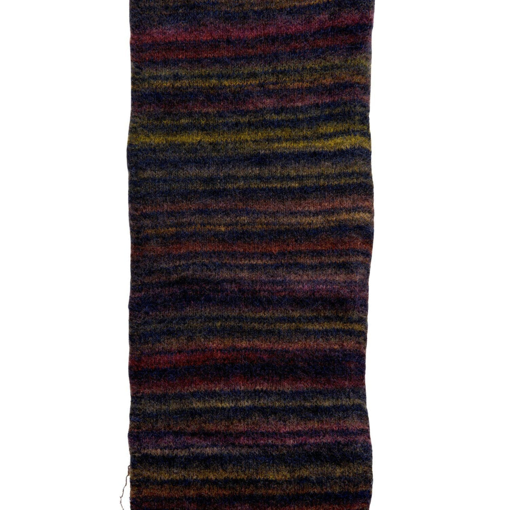 A close-up of a striped knit fabric, likely a scarf or sweater, featuring horizontal stripes of dark navy, burgundy, purple, and yellow on a white background.