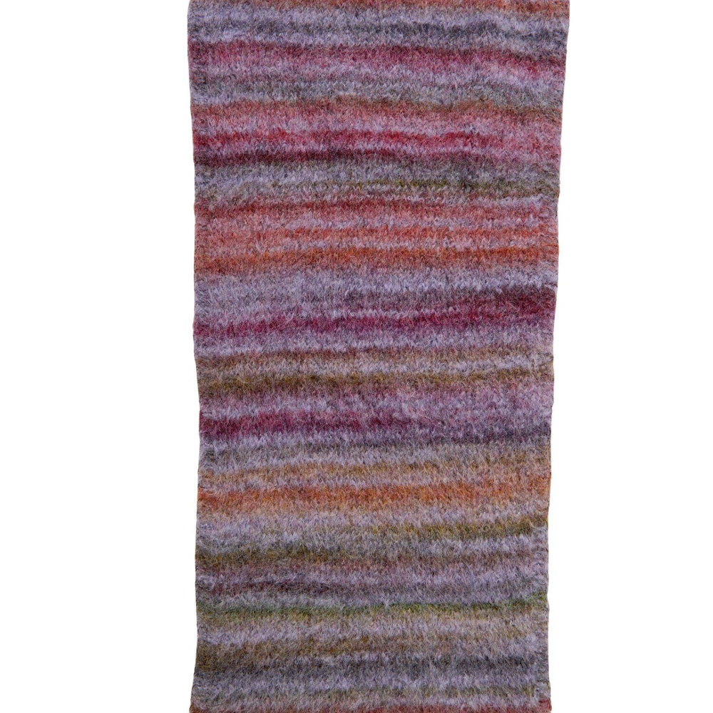 A close-up of a textured, fuzzy striped fabric or scarf with horizontal bands of purple, pink, orange, and brown on a white background.