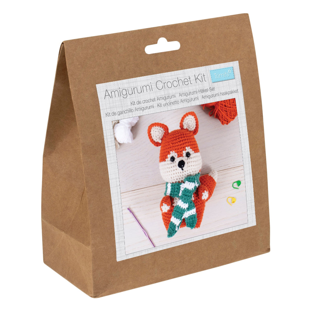 Amigurumi Crochet Kit in a brown paper bag package, featuring a printed front label with a crocheted fox illustration and small crochet yarn balls visible at the top.