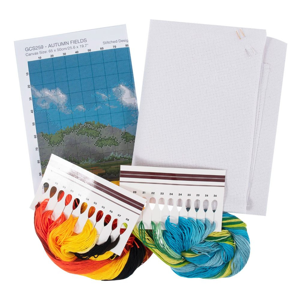 A needlework kit laid out on a white background, including a printed canvas design sheet, two large white mesh canvases, two skeins of embroidery floss in warm orange/yellow/black and cool blue/green tones, and two color reference cards.