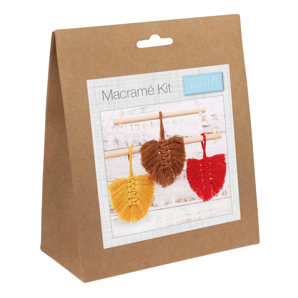 A brown kraft paper bag package labeled 'Macramé Kit' with a photo of three woven macramé leaves in yellow, brown, and red on a white background.