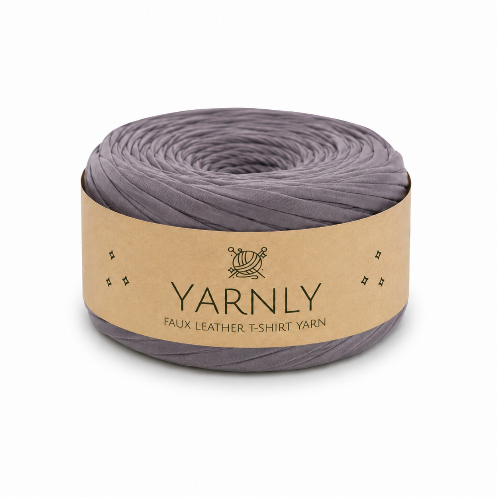 A roll of Yarnly faux leather t-shirt yarn in a muted grayish purple color, wrapped in a kraft paper band with the brand name 'YARNLY' printed on it, set against a plain white background.