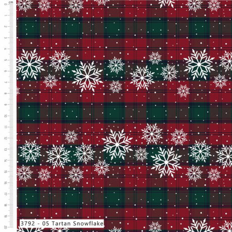 A close-up of a tartan fabric pattern with red and dark green plaid stripes, decorated with rows of white snowflakes and small white dots. A white ruler scale is visible along the left edge, and a label at the bottom reads '3792 - 05 Tartan Snowflake'.