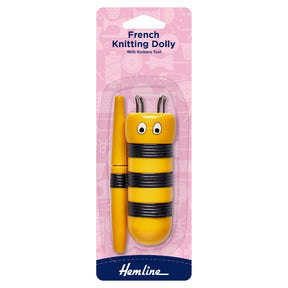 Yellow French knitting dolly with black stripes on pink packaging, featuring the brand 'Hemline'.