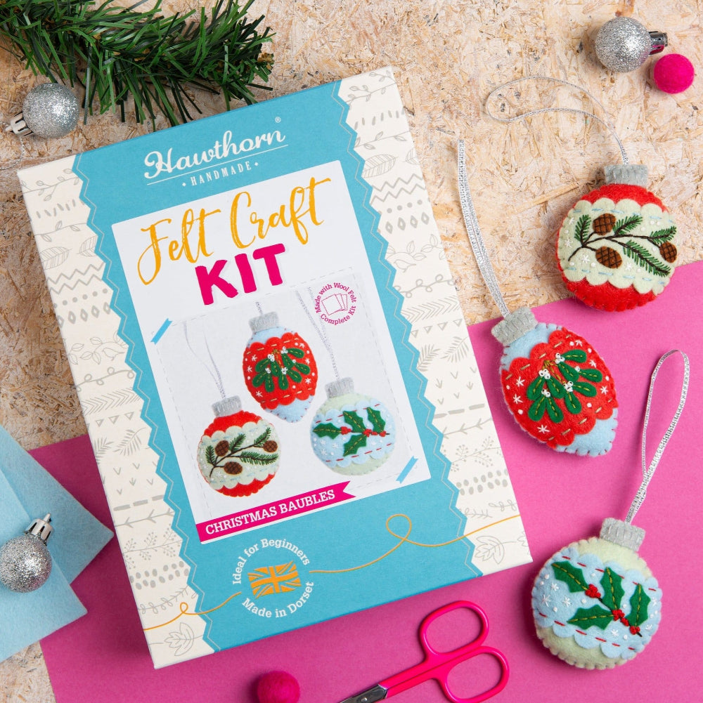 Felt craft kit with Christmas baubles on a pink and beige background