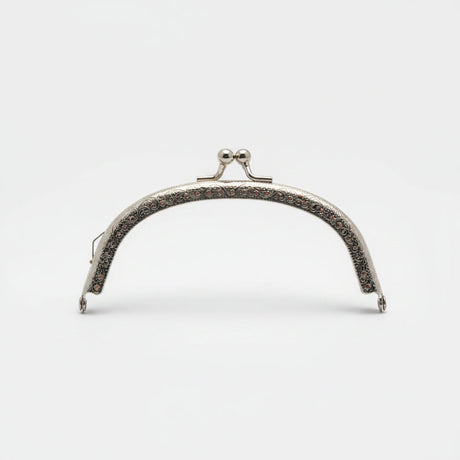 A silver metal bag clasp with clear rhinestones, presented in its pink retail packaging by Hemline.