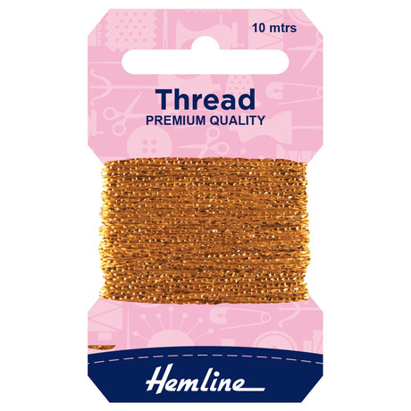 A package of Hemline premium quality gold sewing thread, 10 meters, wound on a cardboard spool with a pink header card and a navy blue brand label at the bottom.