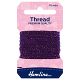 A package of Hemline thread spool, featuring a dark purple thread wound around a cardboard hanger with a pink top card and a navy blue bottom section.