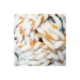 A close-up of chunky, thick yarn with a fluffy texture, primarily white with variegated accents of mustard yellow, orange, and hints of blue and green.