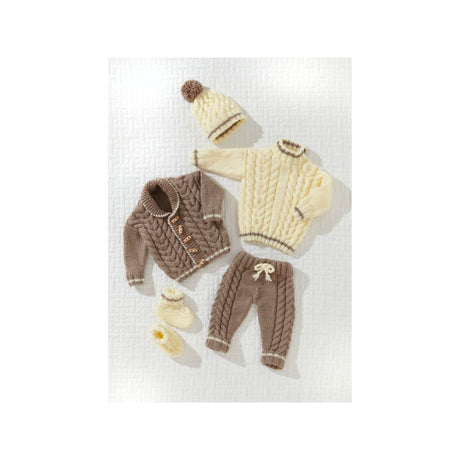 A baby knit clothing set laid flat on a white textured background, including a cream cable-knit sweater, a brown cable-knit cardigan, matching brown pants with a cream bow, a cream beanie with a brown pom-pom, and cream booties.