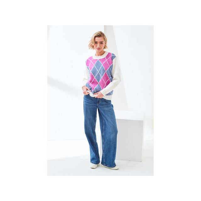 A woman modeling a sleeveless argyle sweater vest in pink, blue, and purple over a white long-sleeve shirt, paired with wide-leg blue jeans and white sneakers, set against a minimalist white studio background.