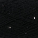 Close-up of black yarn with scattered small silver sequins woven throughout.