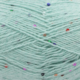 Close-up of mint green yarn with scattered small multicoloured sequins 