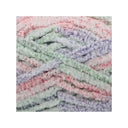 A close-up of fluffy, fuzzy chenille yarn strands in a pastel tie-dye mix of pink, green, purple, and white, arranged in soft horizontal layers.