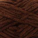 A close-up of thick, plush yarn in a rich dark brown color, showing its soft, fuzzy texture.