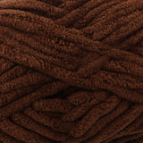 A close-up of thick, plush yarn in a rich dark brown color, showing its soft, fuzzy texture.