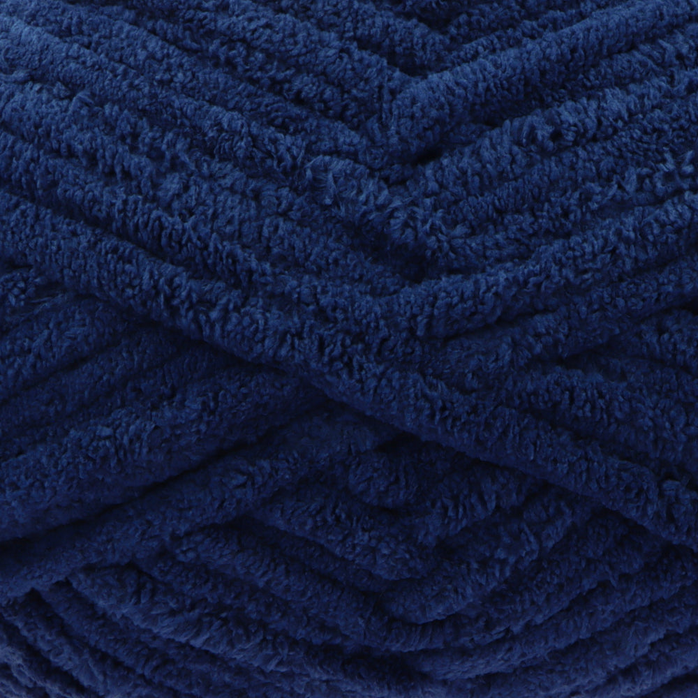 A close-up of thick, plush yarn in a deep navy blue colour, showing the soft, textured surface of the strands.