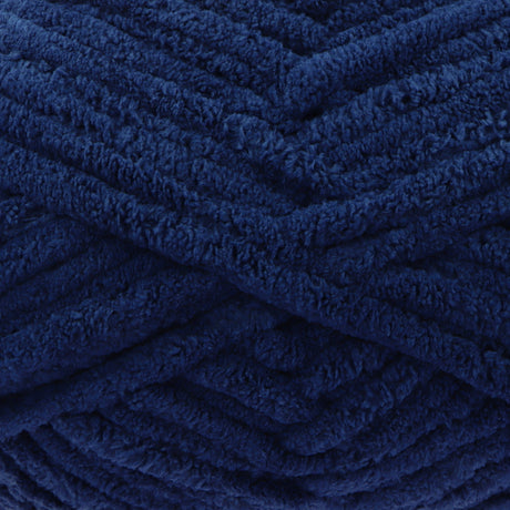 A close-up of thick, plush yarn in a deep navy blue colour, showing the soft, textured surface of the strands.