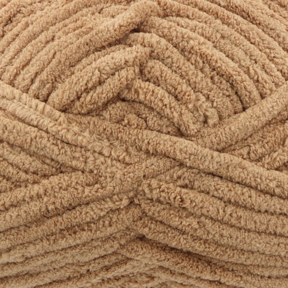 A close-up of thick, plush chenille yarn in a warm tan or light brown colour, showing the soft, looped texture of the material.