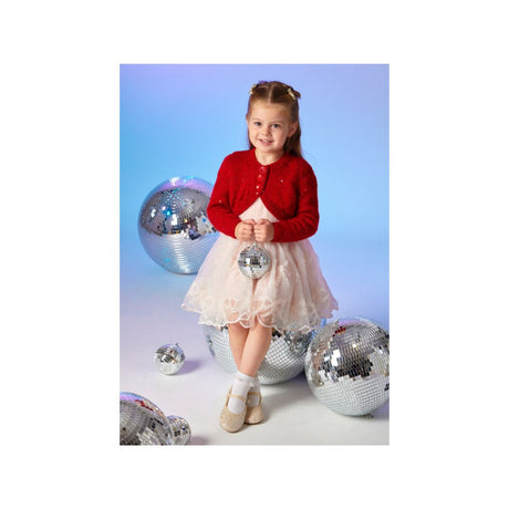 A young girl wearing a festive red cardigan and a light pink tulle dress sits on a silver disco ball against a blue gradient background, surrounded by other reflective disco balls.