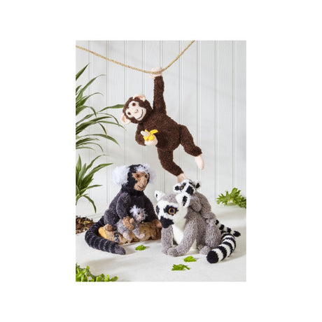 A set of plush animal toys including a brown monkey hanging from a rope, a gray and white lemur, and a dark monkey holding a baby figure, displayed against a white paneled wall with green plant accents.