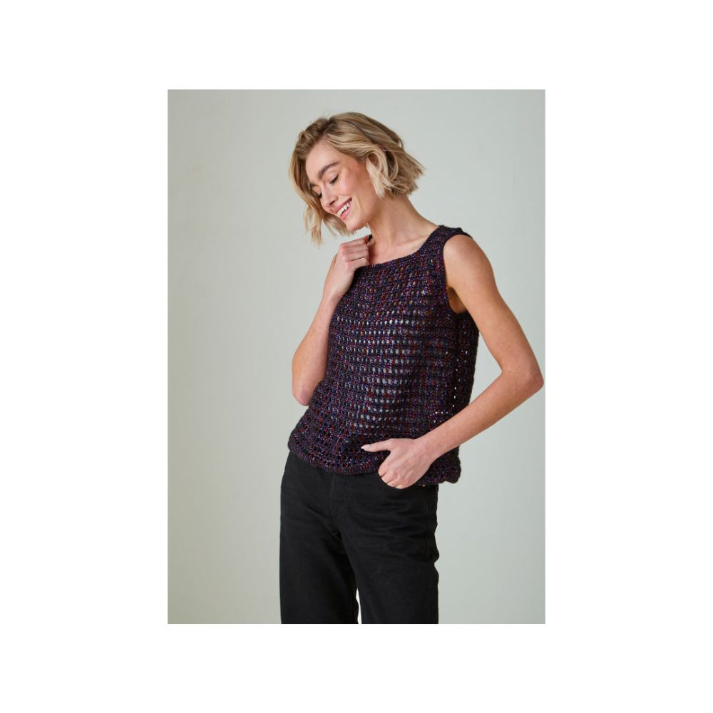 A woman modeling a sleeveless, textured knit top in a dark purple and black pattern, paired with black pants, against a solid light grey background.