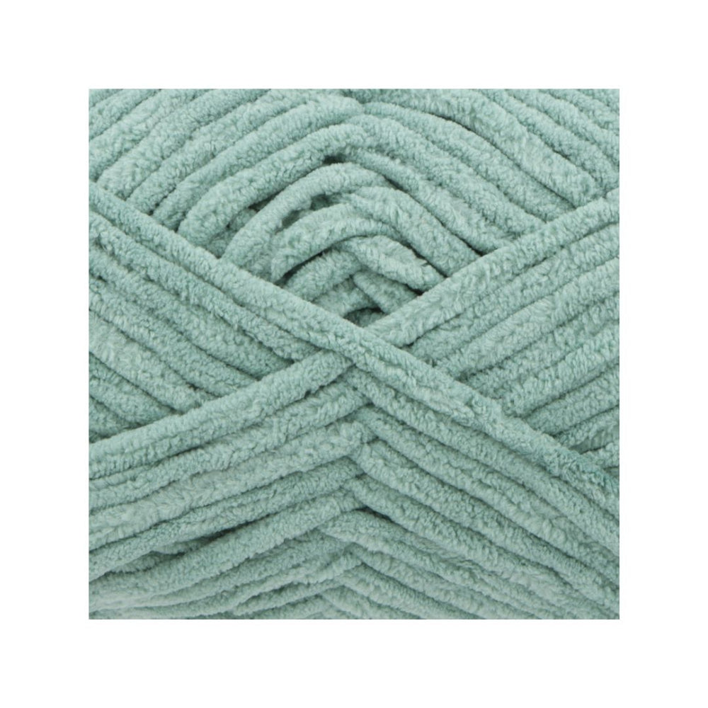 A close-up of chunky, plush chenille yarn in a dusty sage green colour, arranged in a neat square on a white background.