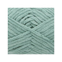 A close-up of chunky, plush chenille yarn in a dusty sage green colour, arranged in a neat square on a white background.