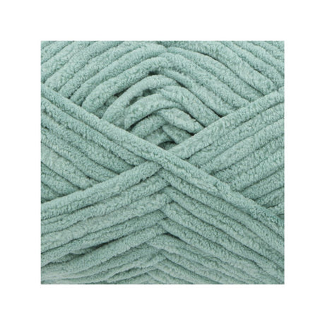 A close-up of chunky, plush chenille yarn in a dusty sage green colour, arranged in a neat square on a white background.