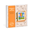 A boxed craft kit labeled 'KINUSAIGA KIT BALLOON' by Peak Dale Products, shown at a slight angle on a white background. The package is white with a large orange panel and floral-patterned paper wrapping around the right side, featuring an illustration of a colorful hot air balloon.