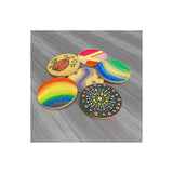 Five round wooden coasters with colourful painted designs, including a rainbow, a ladybug, and a mandala pattern, arranged on a grey wood-textured background.