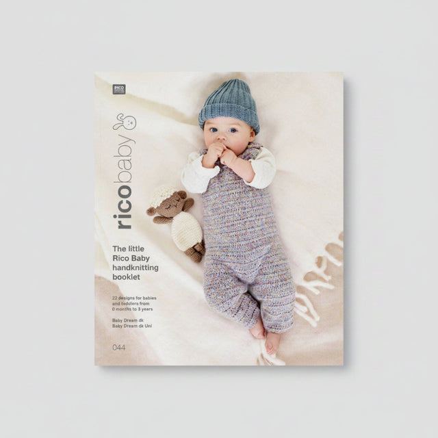 Rico Baby handknitting booklet cover featuring a baby lying on a soft cream blanket, wearing a knitted blue hat and a multicolored knitted romper, with a small knitted sheep toy beside them. The left side includes the title 'The little Rico Baby handknitting booklet' and the RICO BABY logo.