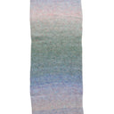 A close-up of a knitted fabric or scarf showing a soft ombre gradient transitioning from pale pink at the top, through muted green in the middle, to light blue and lavender at the bottom, set against a plain white background.