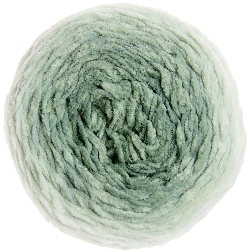 A single ball of soft, fuzzy yarn in a pale sage green color, photographed from directly above on a solid white background.