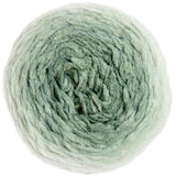 A single ball of soft, fuzzy yarn in a pale sage green color, photographed from directly above on a solid white background.