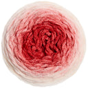 A top-down view of a round ball of plush, fuzzy yarn with a color gradient transitioning from off-white at the outer edges to light pink and deep red in the center, isolated on a white background.