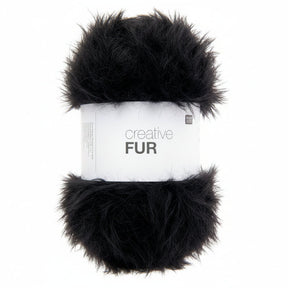 A skein of black faux fur yarn wrapped in a white paper band labeled 'creative FUR' against a plain white background.
