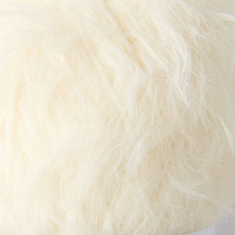A close-up of fluffy faux fur fabric in a warm off-white or cream color.