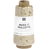 A spool of Rico Design Creative Make It Paillelette craft thread, featuring a white paper label with black text and a brown cardboard core, set against a plain white background.