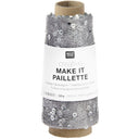 A spool of silver thread with attached sequins, wrapped in a white paper label that reads 'RICO DESIGN creative MAKE IT PAILLETTE'.