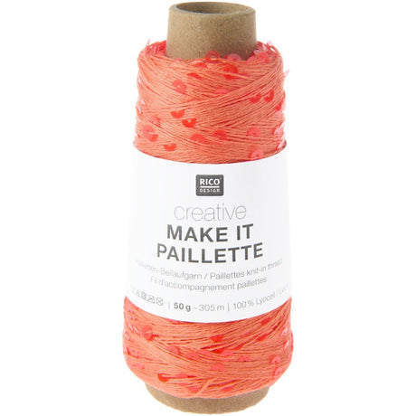 A spool of Rico Design Creative Make It Paillelette yarn in a vibrant coral-orange color, wound on a brown cardboard core with a white paper label.
